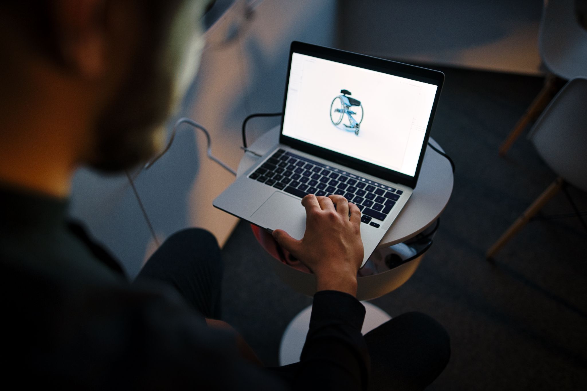 Person arbeitet im Halbdunkel am Laptop, Bildschirm leuchtet
