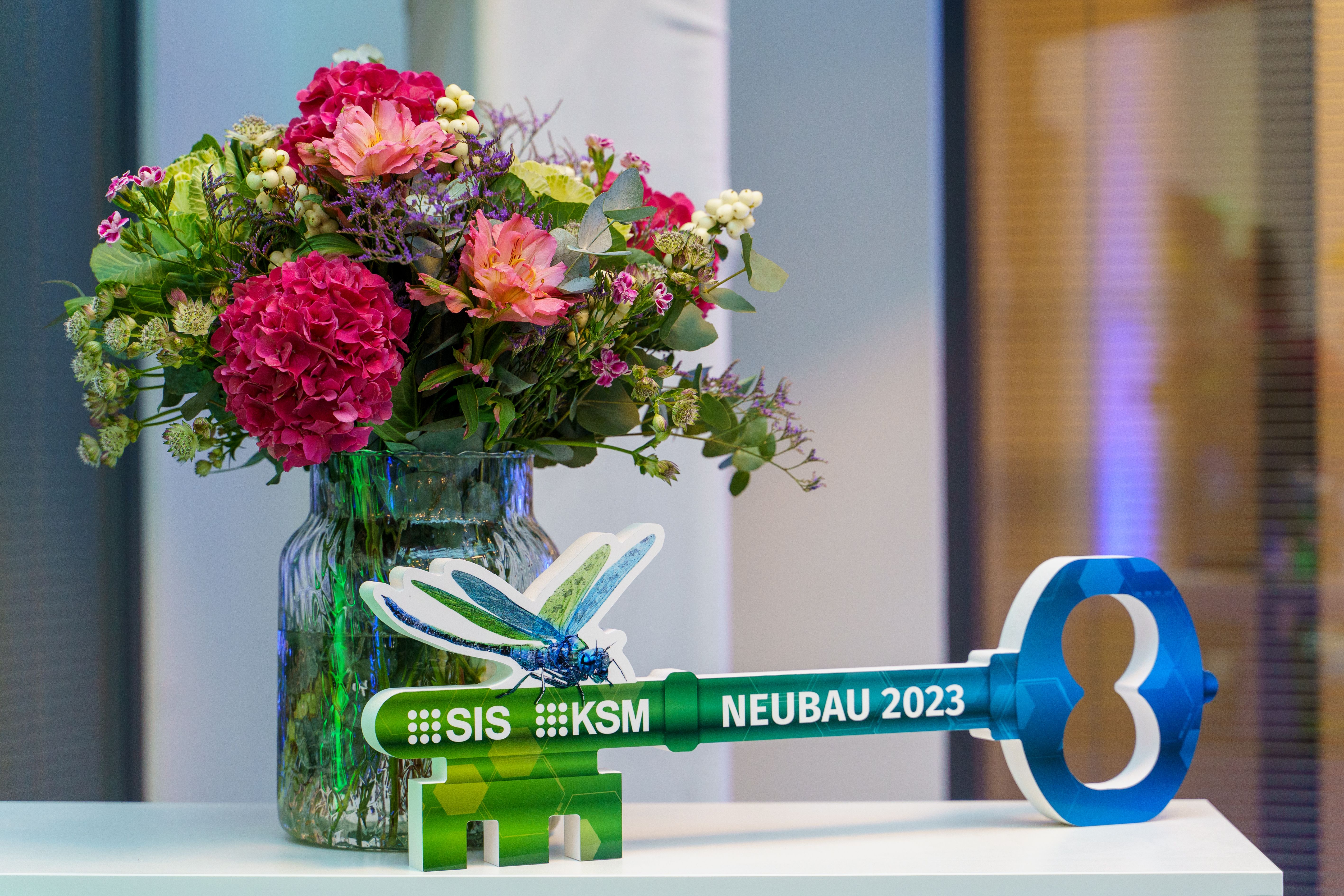 Blumenstrauß neben einem großen Schlüssel als Dekoration bei einer Feier